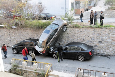 轿车失控翻墙，司机与爱妻携手惊魂瞬间